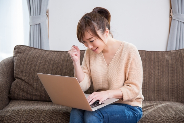 パソコンの前で楽しそうにしている女性の写真