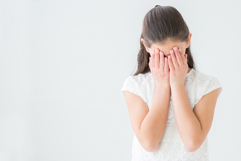 恥ずかしくて顔を隠している女性