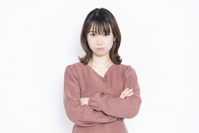 腕組みして黙っている女性