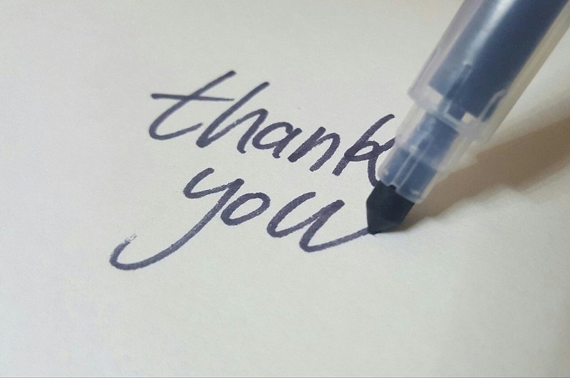 紙にthank youと書いている